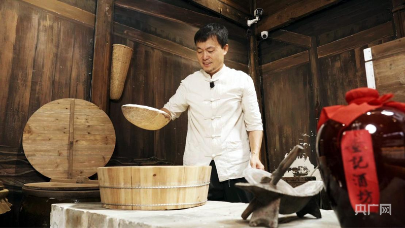 查永红向游客展示酿酒技艺(央广网记者 郇康新 摄)